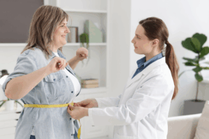 Weight loss - Doctor measuring a patient's waist
